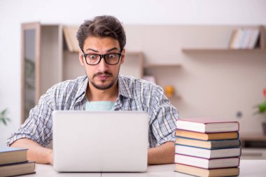 Evde sınava hazırlanan genç bir erkek öğrenci.