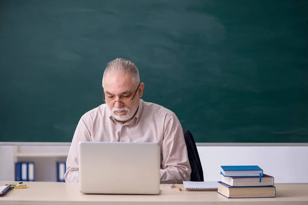 Oude mannelijke leraar voor schoolbord — Stockfoto