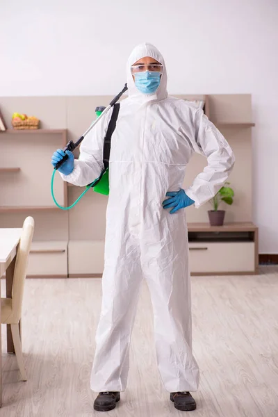 Young male contractor disinfecting at home — Stok fotoğraf