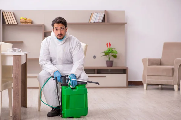 Young male contractor disinfecting at home — Φωτογραφία Αρχείου