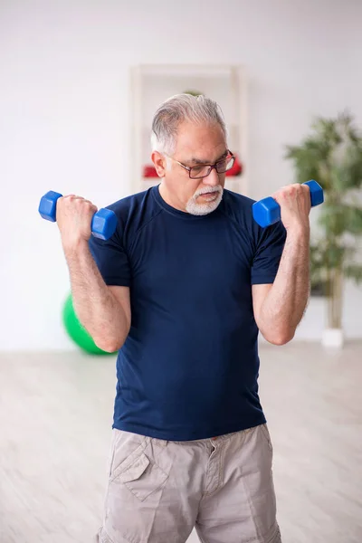 Starzec robi ćwiczenia sportowe w pomieszczeniu — Zdjęcie stockowe