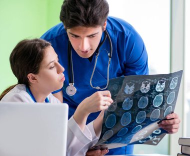 Kadın ve erkek doktorlar radyologlar klinikte çalışıyor.