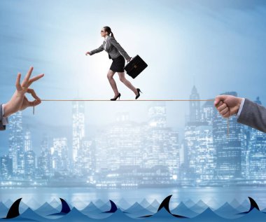 İş kadını iş konseptinde sıkı bir ipin ucunda yürüyor