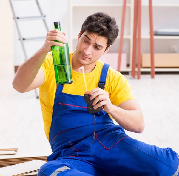 Opravář podlah pije alkohol během přestávky — Stock fotografie