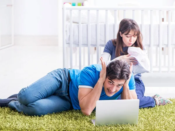 Young parents with their newborn baby sitting on the carpet — Stock Photo, Image