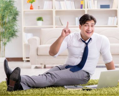 İş adamı ofiste yerde oturuyor.