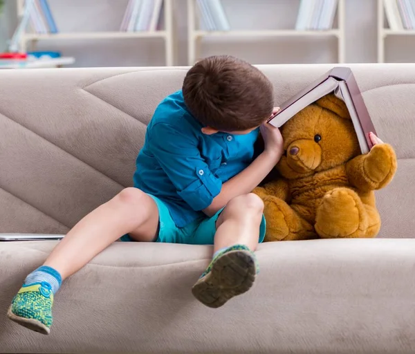 Kleine jongen die thuis boeken leest — Stockfoto