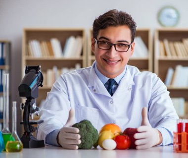 Erkek doktor meyve ve sebzeleri kontrol ediyor.