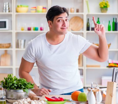 Genç aşçı mutfakta çalışıyor.