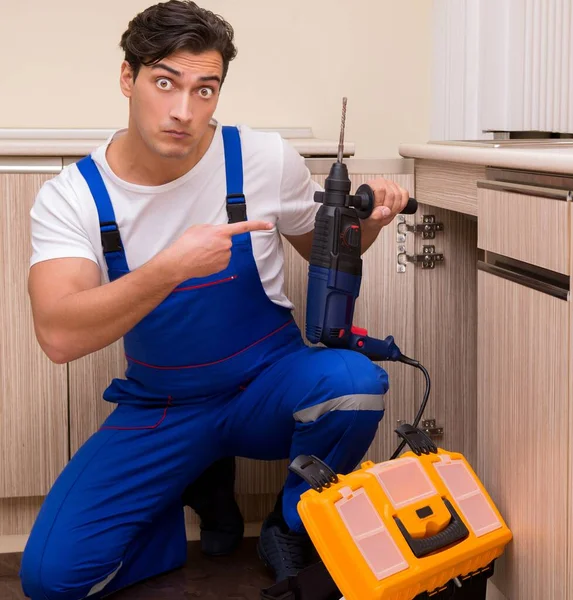 Joven reparador trabajando en la cocina — Foto de Stock