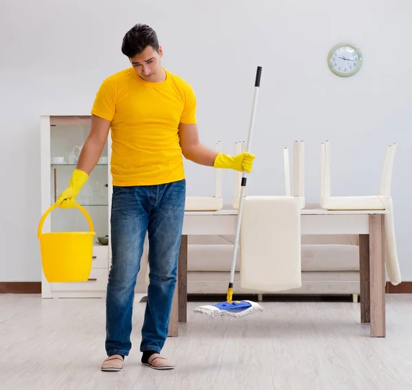 Homem limpando a casa ajudando sua esposa — Fotografia de Stock