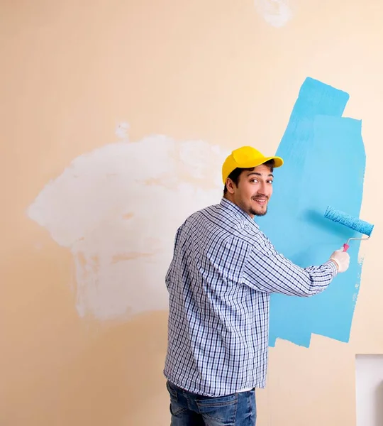 Pintor hombre pintando la pared en casa — Foto de Stock