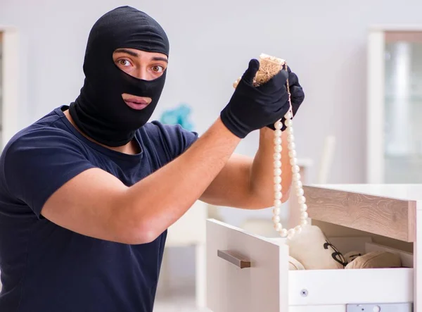 Ladrão usando balaclava roubando coisas valiosas — Fotografia de Stock