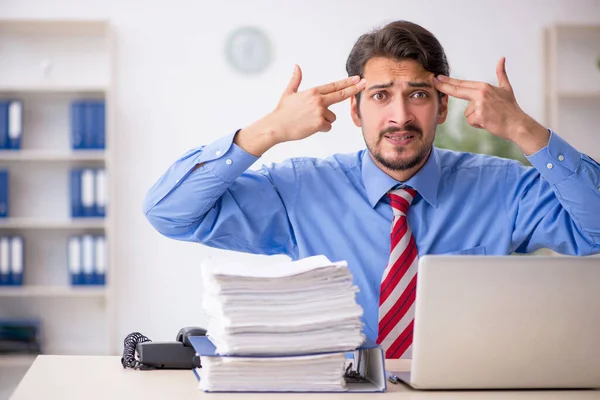 Jovem funcionário masculino infeliz com excesso de trabalho no escritório — Fotografia de Stock