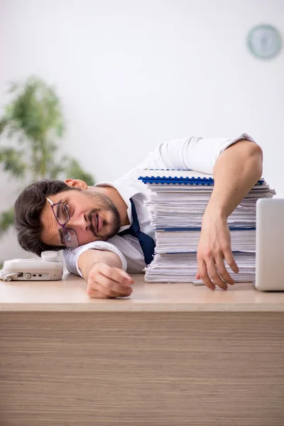 Jovem funcionário masculino infeliz com excesso de trabalho no escritório — Fotografia de Stock