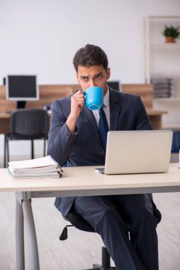 Molada kahve içen genç bir erkek.