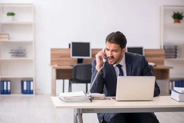 Jeune employé masculin assis sur le lieu de travail — Photo