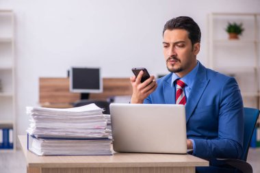 Genç erkek çalışan işyerinde aşırı çalışmaktan memnun değil.