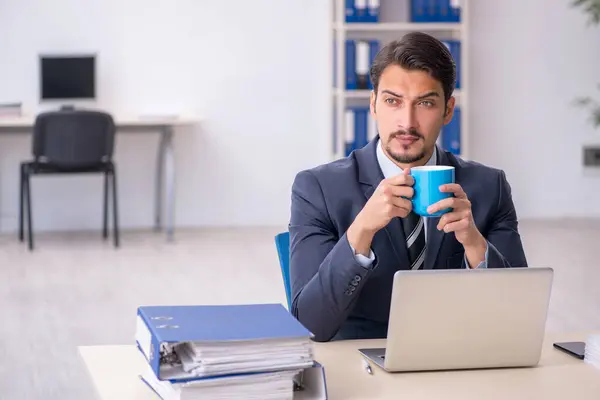 Jonge mannelijke werknemer die koffie drinkt tijdens de pauze — Stockfoto