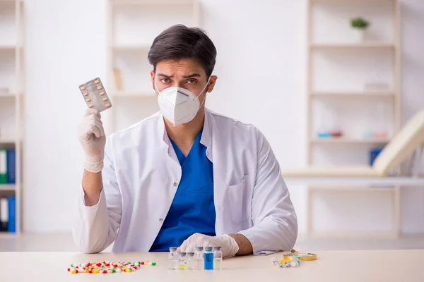 Jovem médico masculino e muitas pílulas — Fotografia de Stock