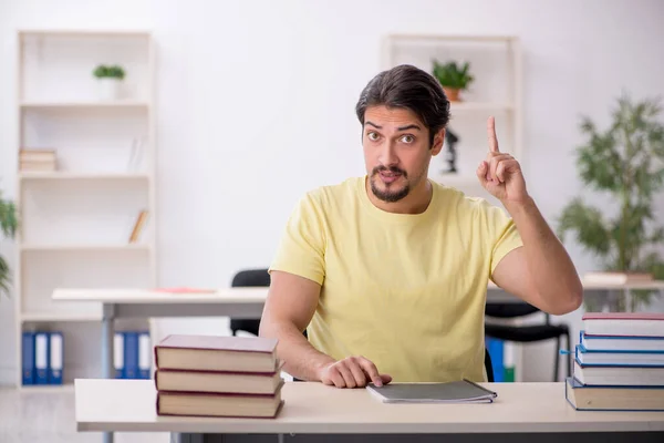 Ung manlig student förbereder sig för tentor i klassrummet — Stockfoto