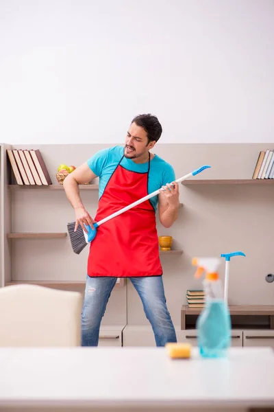 Jovem empreiteiro limpando a casa — Fotografia de Stock