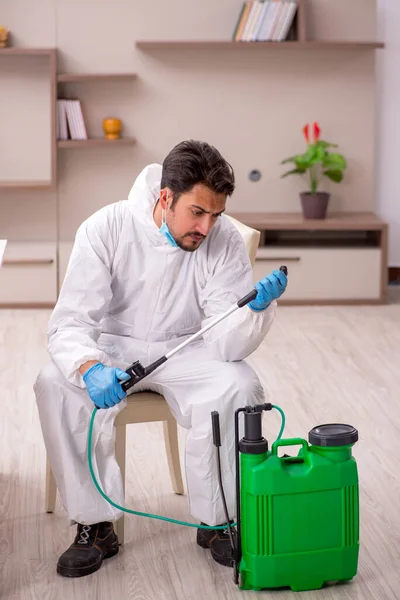 Young male contractor disinfecting at home — Φωτογραφία Αρχείου