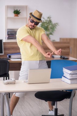 Genç bir erkek işçi iş yerinde geziye hazırlanıyor.