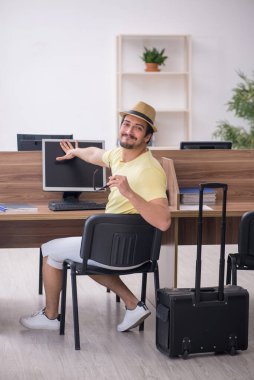 Genç bir erkek işçi iş yerinde geziye hazırlanıyor.