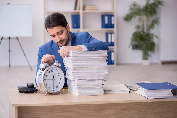 Jovem empregado do sexo masculino no conceito de gerenciamento de tempo no escritório — Fotografia de Stock
