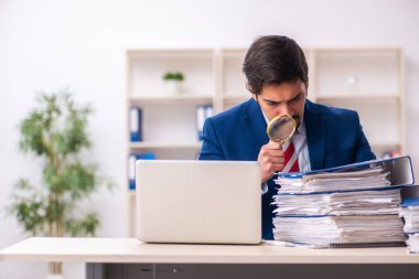 Ofisteki aşırı işten memnun olmayan genç bir erkek işçi.