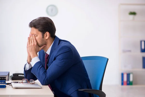 Giovane dipendente maschio infelice con un lavoro eccessivo in ufficio — Foto Stock