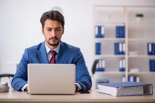 Joven empleado masculino que trabaja en el lugar de trabajo — Foto de Stock