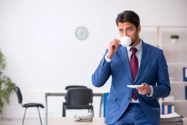 Joven empleado masculino bebiendo café durante el descanso —  Fotos de Stock