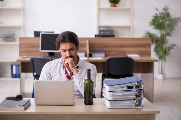 Junge alkoholabhängige männliche Angestellte arbeitet im Büro — Stockfoto
