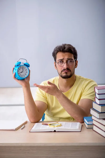 Jonge mannelijke student bereidt zich voor op examens in de klas — Stockfoto