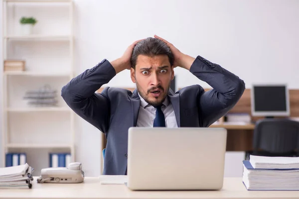 Empleado joven sentado en el lugar de trabajo — Foto de Stock