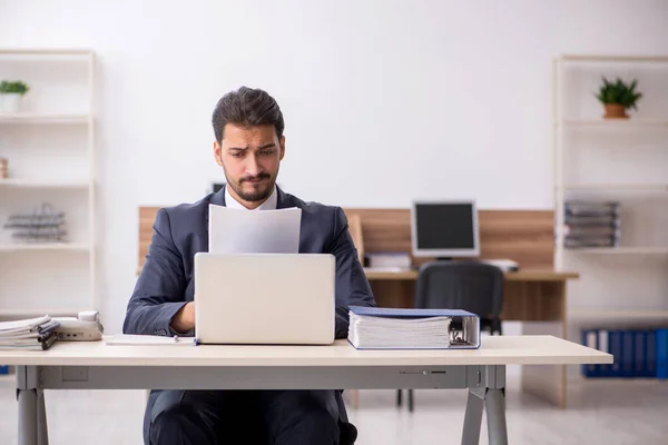 Junge männliche Mitarbeiter sitzen am Arbeitsplatz — Stockfoto