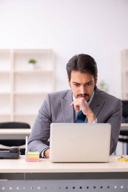 Ofiste çalışan genç bir erkek.