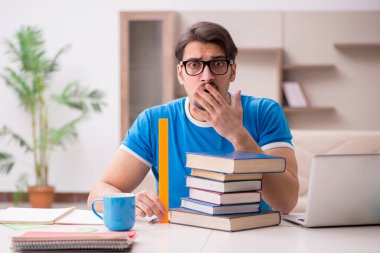 Evde okuyan genç bir erkek öğrenci.