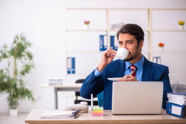 Molada kahve içen genç bir erkek.