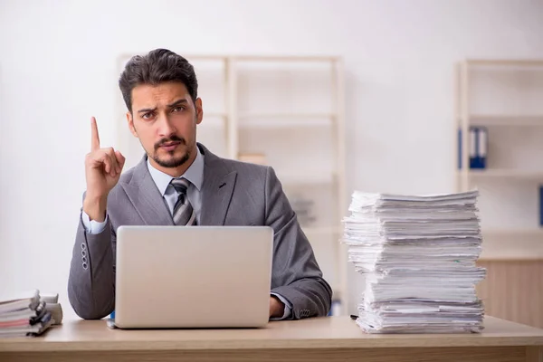 Joven empleado masculino descontento con el trabajo excesivo en la oficina — Foto de Stock