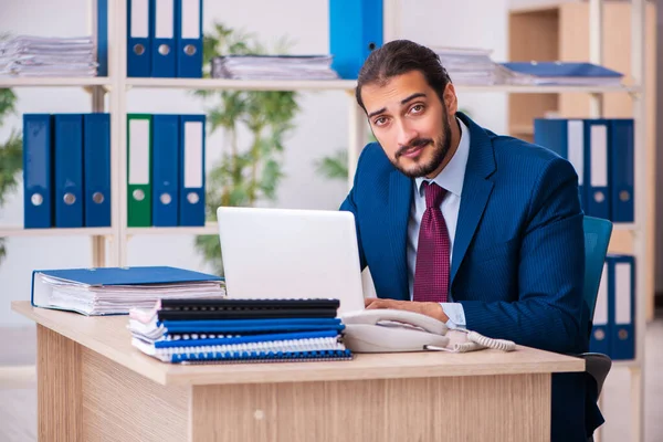 Joven empleado masculino y demasiados trabajan en la oficina — Foto de Stock