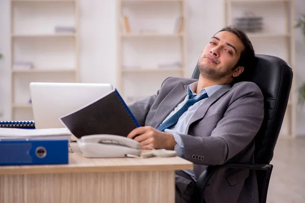 Joven empleado masculino descontento con el trabajo excesivo en la oficina — Foto de Stock