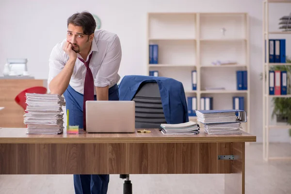 Jeune employé masculin et trop de travail au bureau — Photo