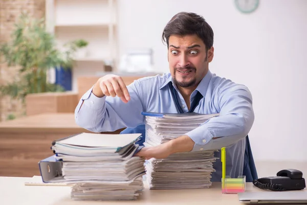 Giovane dipendente maschio e troppo lavoro in ufficio — Foto Stock