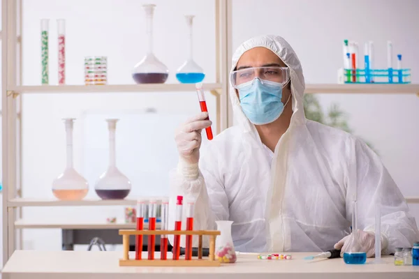 Young male chemist in drugs syntesis concept — Stock Photo, Image
