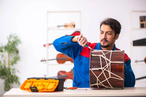 職場で楽器を修理する若い男性 — ストック写真