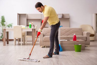 Genç erkek müteahhit evi temizliyor.