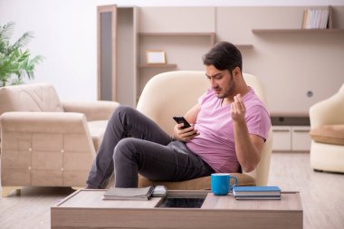 Salgın sırasında evde oturan genç adam.